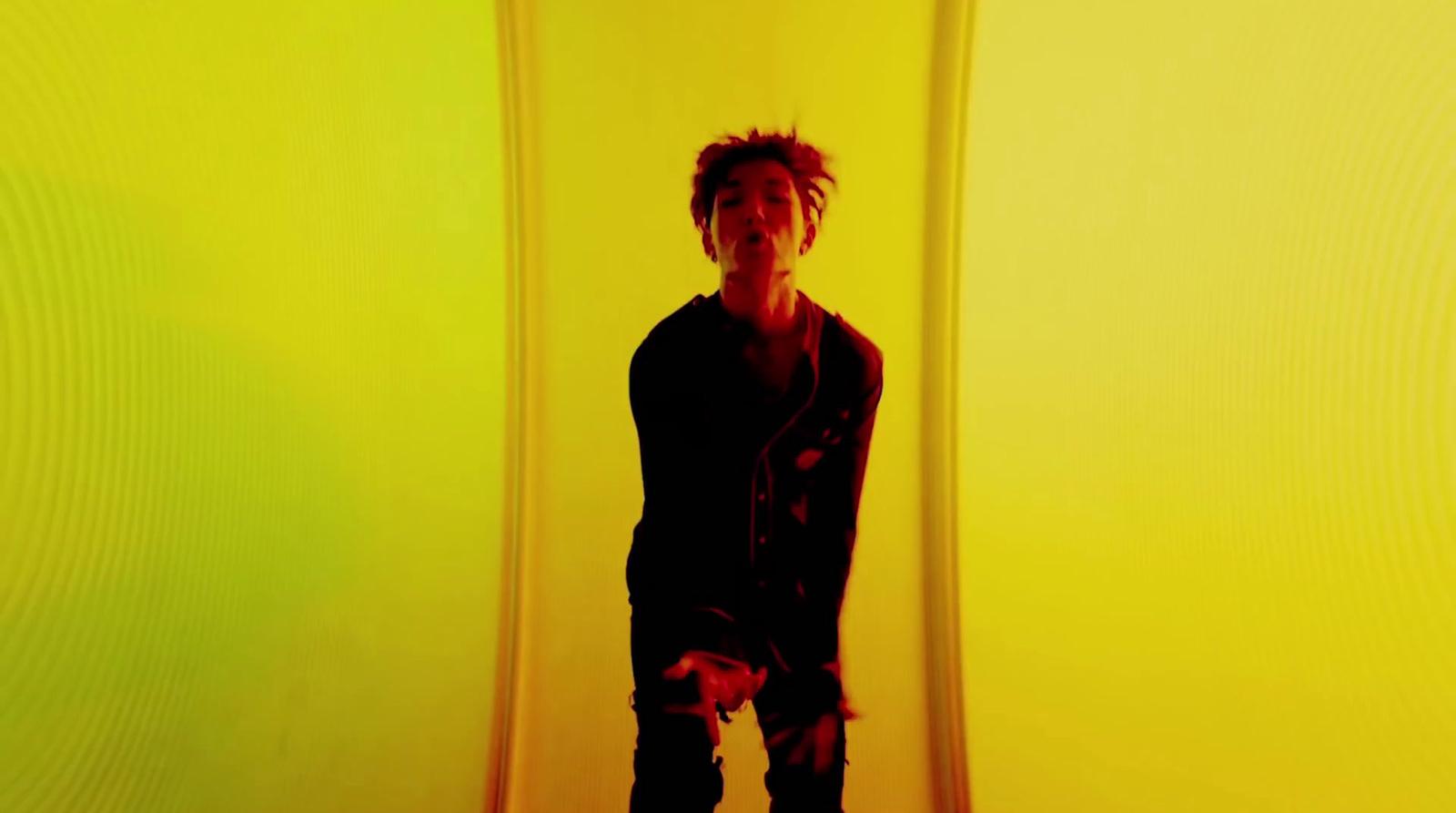 a man standing in front of a yellow wall