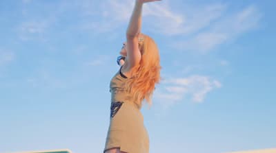 a woman reaching up to catch a frisbee