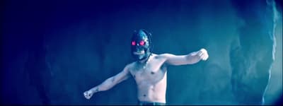 a shirtless man wearing a mask and holding a frisbee
