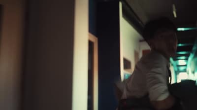 a man walking down a hallway with a backpack