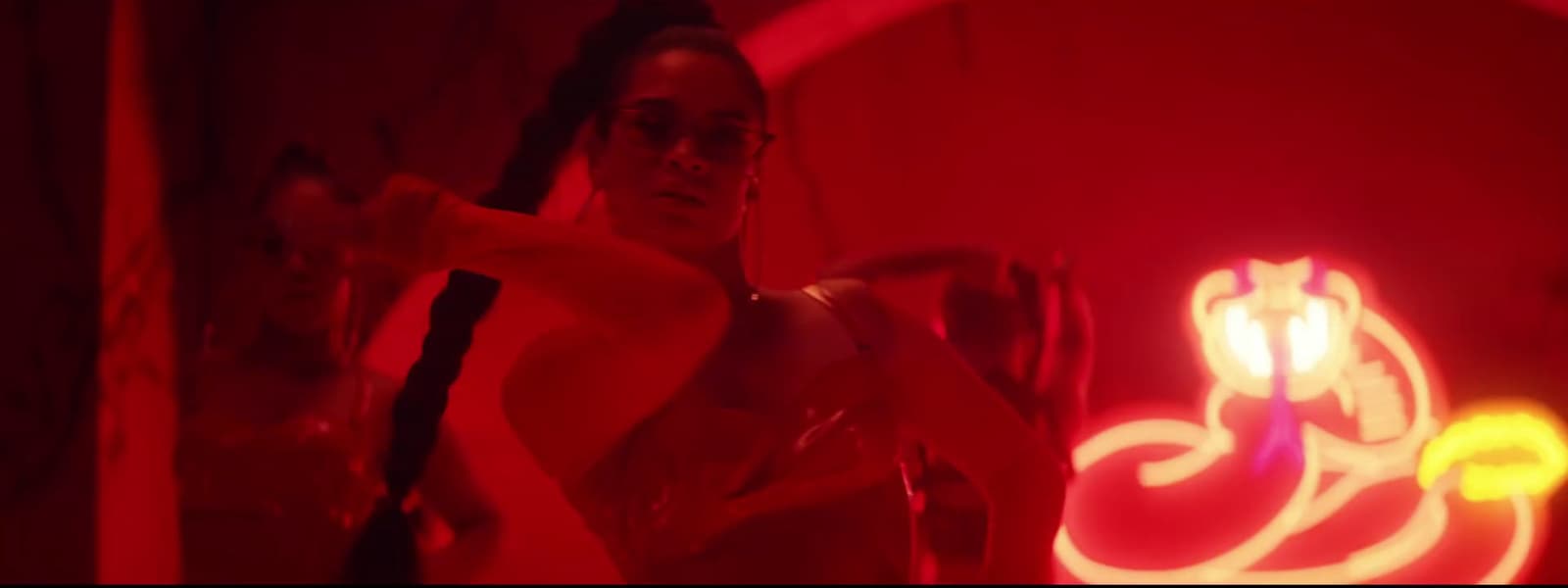 a woman in a red light room holding a knife
