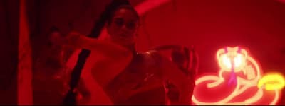 a woman in a red light room holding a knife