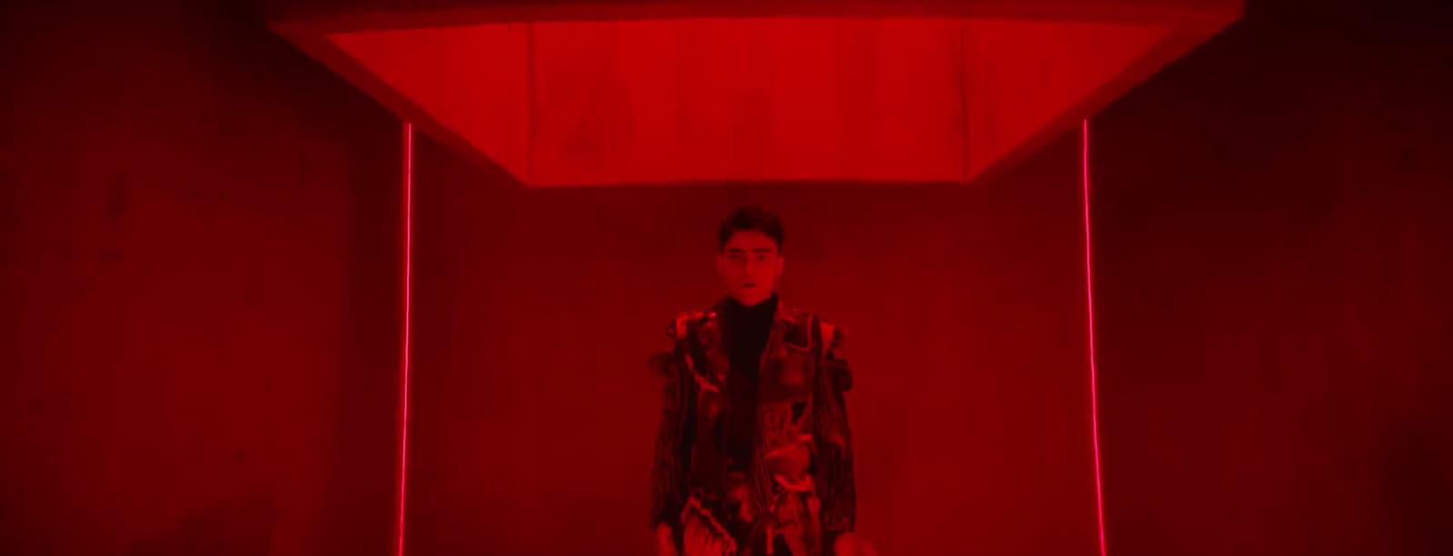 a man standing in a room with a red light