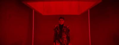 a man standing in a room with a red light