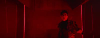 a man standing in a room with red lights