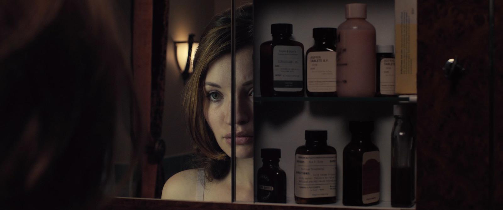 a woman looking at her reflection in a mirror