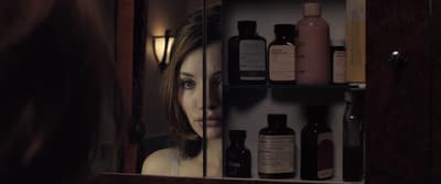a woman looking at her reflection in a mirror