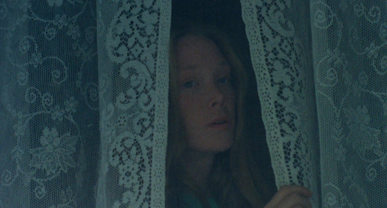 a woman is looking out of a window