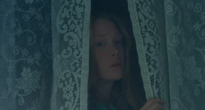 a woman is looking out of a window