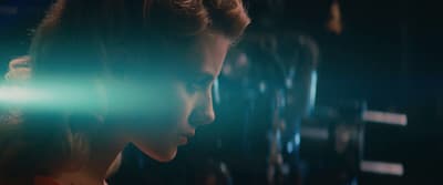 a woman is staring at something in the dark