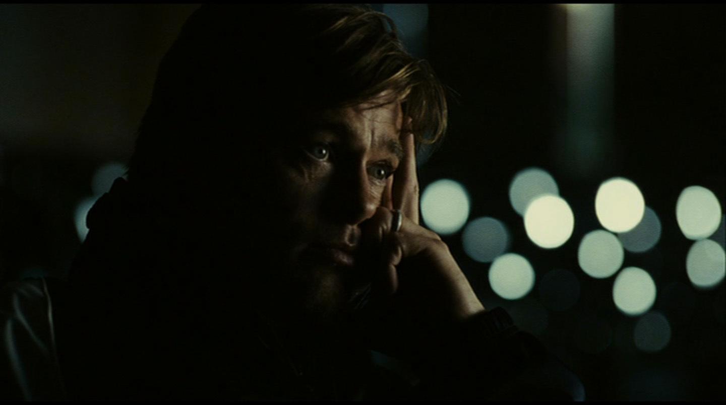 a man with his hand on his face in the dark