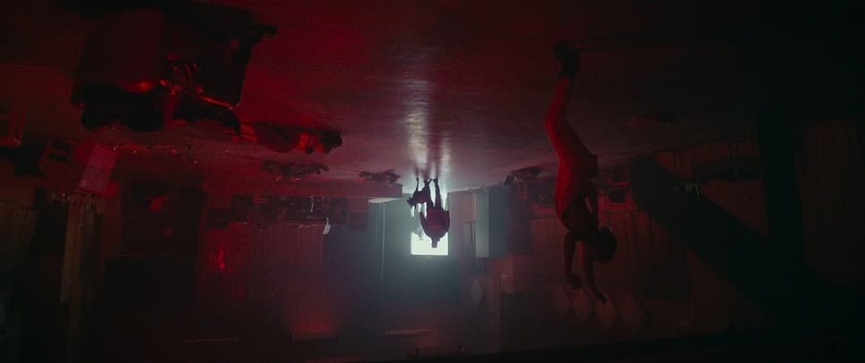 a dark room with a person hanging upside down