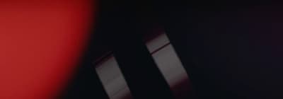 a blurry photo of a clock on a red wall
