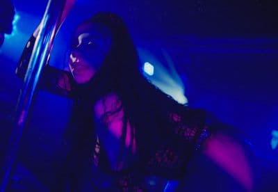 a woman holding a pole in a dark room