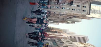 a group of people standing next to each other in front of a tall building