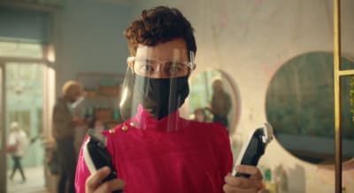 a man in a red shirt holding a pair of scissors