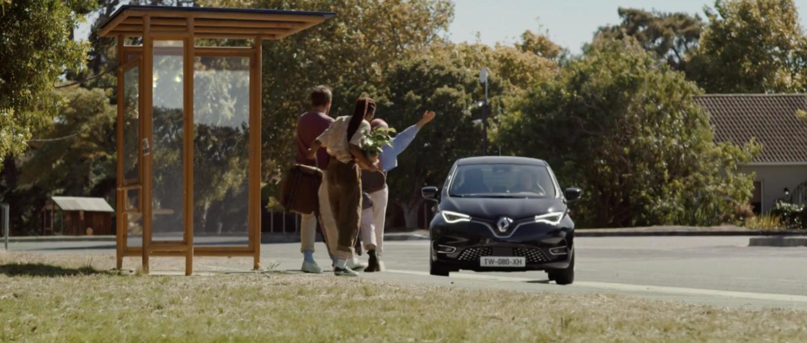 a couple of people walking down a street next to a car