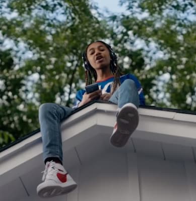 a woman sitting on top of a roof using a cell phone