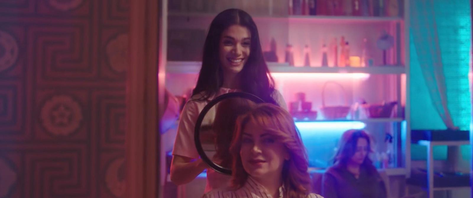 a woman standing next to another woman in a room