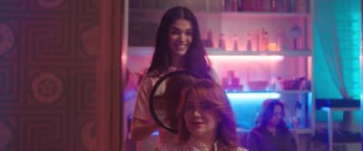 a woman standing next to another woman in a room