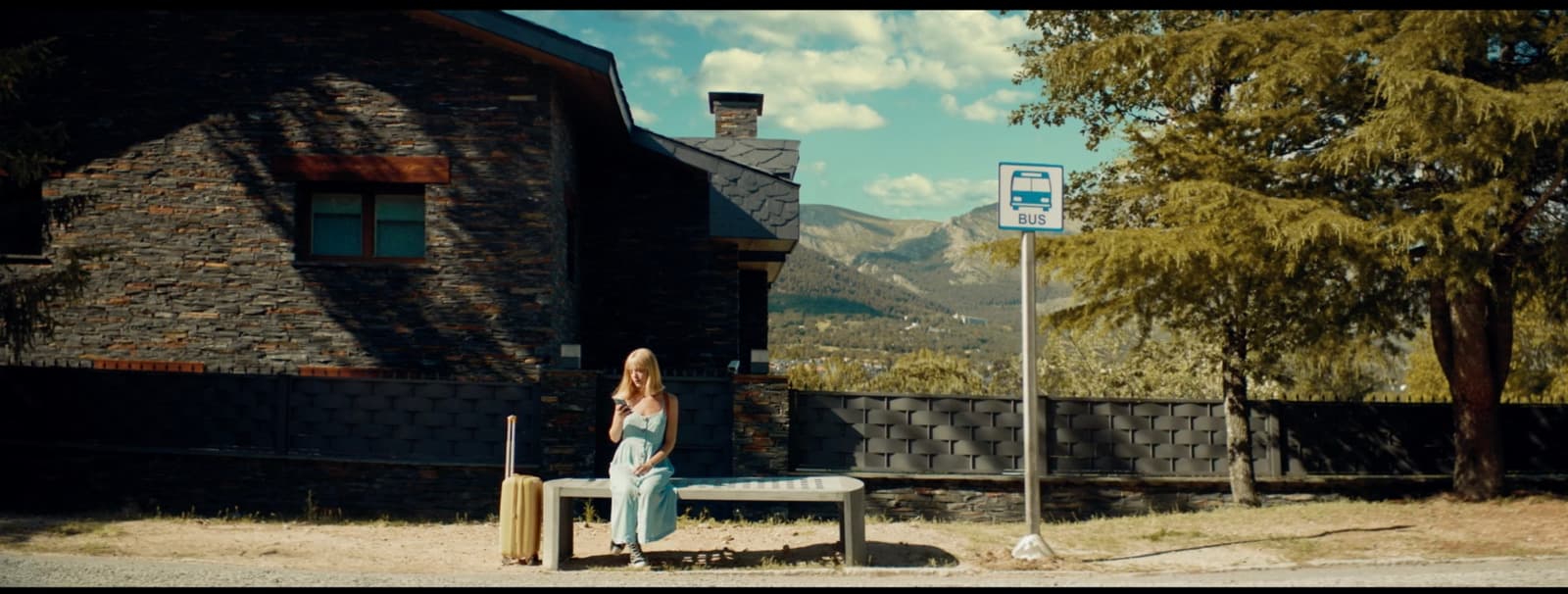 a woman sitting on a bench in front of a building