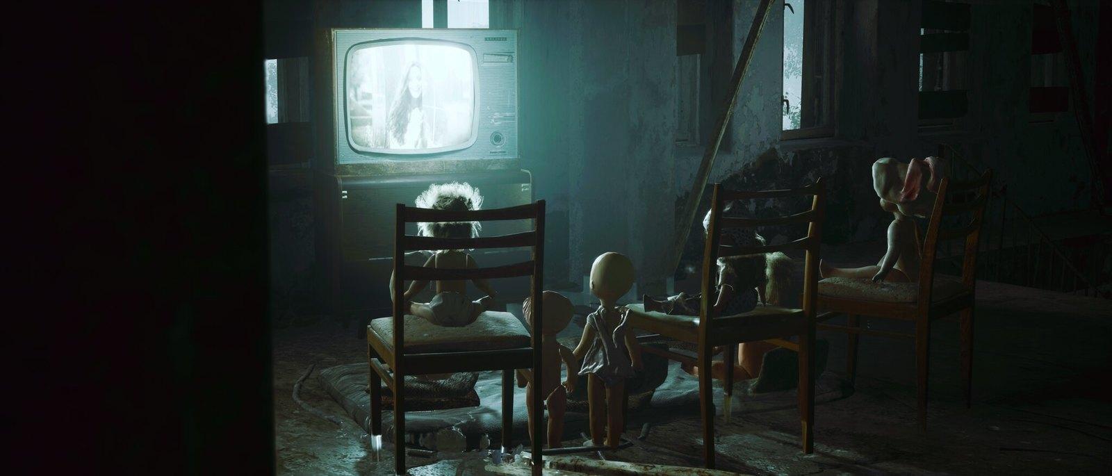 a group of people sitting around a tv in a dark room