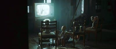 a group of people sitting around a tv in a dark room