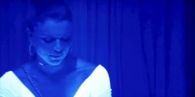 a woman looking at her cell phone in the dark