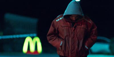 a man in a red jacket holding a skateboard