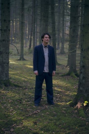 a man standing in the middle of a forest