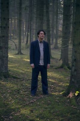 a man standing in the middle of a forest
