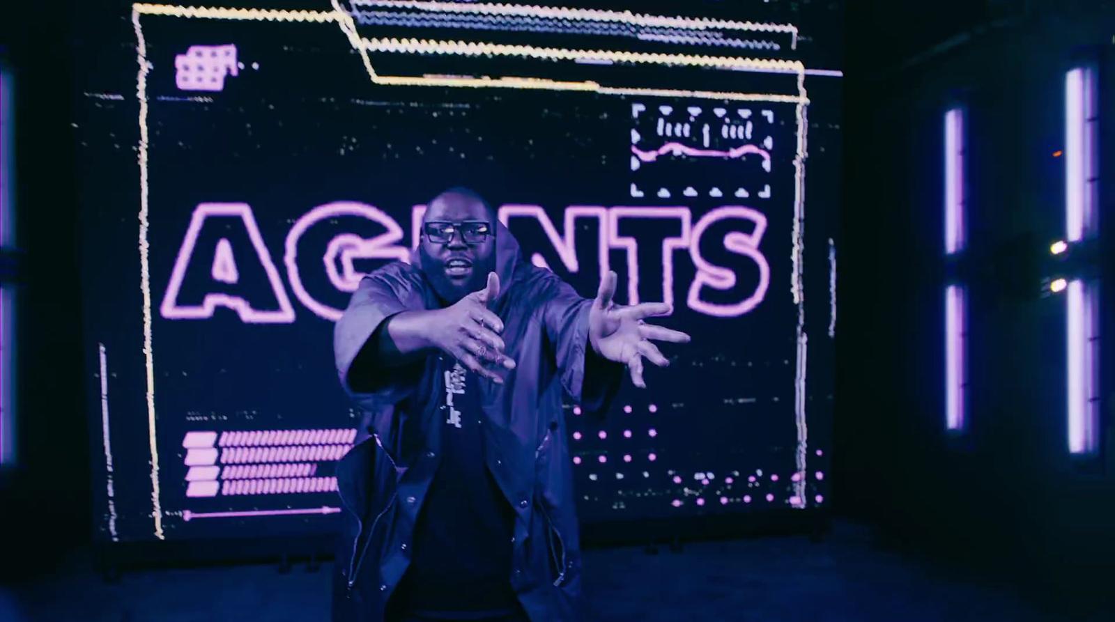 a man standing in front of a neon sign