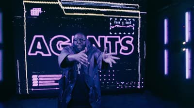 a man standing in front of a neon sign