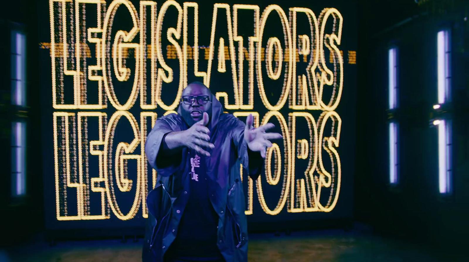 a man standing in front of a neon sign