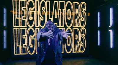 a man standing in front of a neon sign