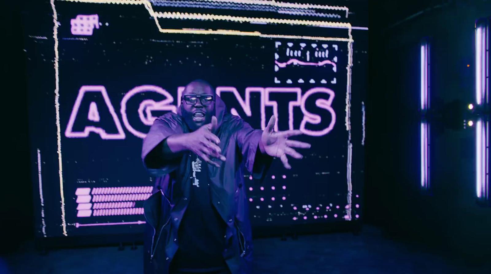 a man standing in front of a neon sign