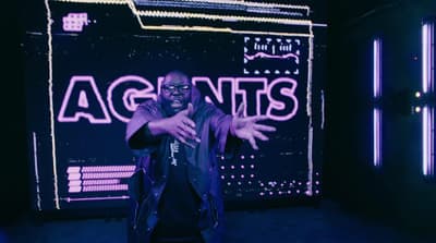 a man standing in front of a neon sign