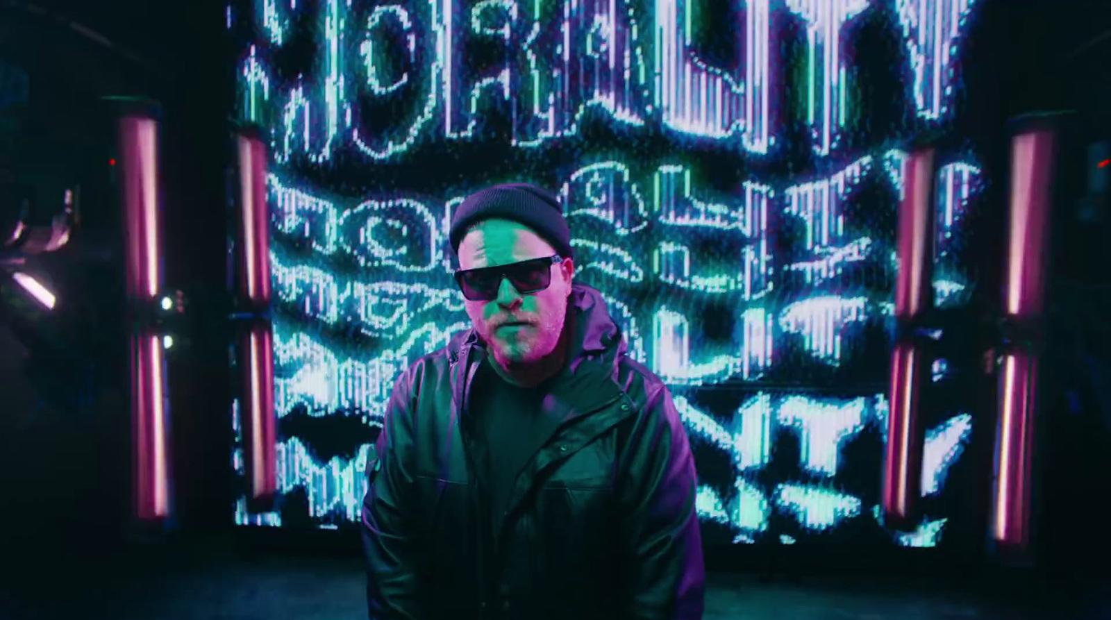 a man standing in front of a neon sign