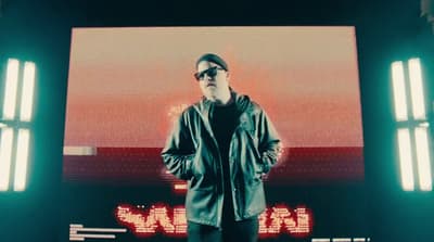 a man standing in front of a large screen