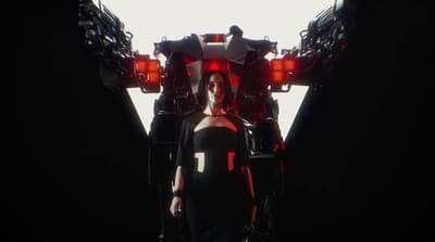 a woman in a black dress walking through a tunnel