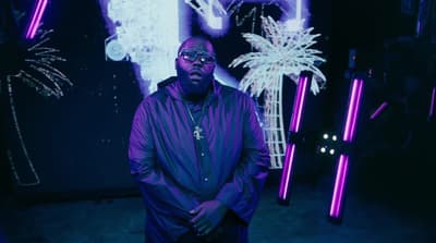 a man standing in front of a neon sign