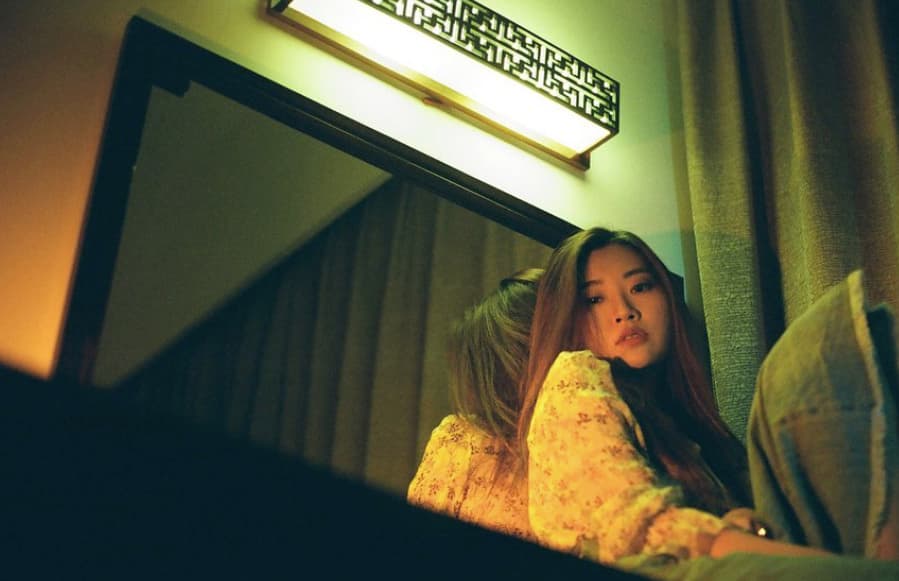 a woman sitting in front of a mirror in a room