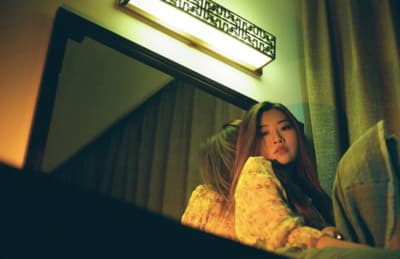 a woman sitting in front of a mirror in a room