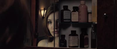 a woman looking at her reflection in a mirror