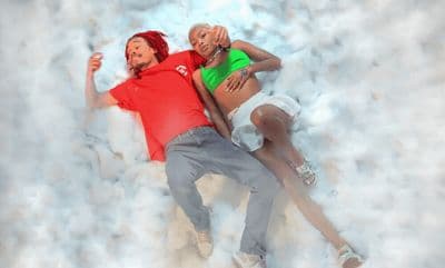 a man and a woman are laying on the snow