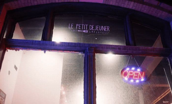 a store front with a neon sign on the window