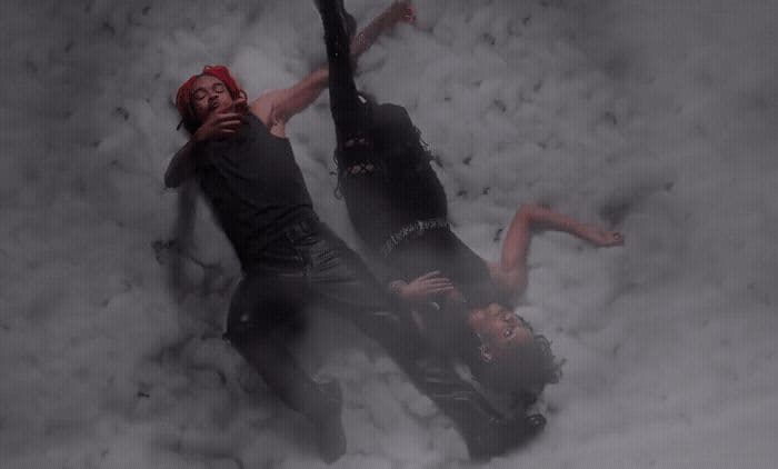 a man and a woman laying in the snow