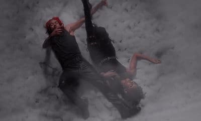 a man and a woman laying in the snow