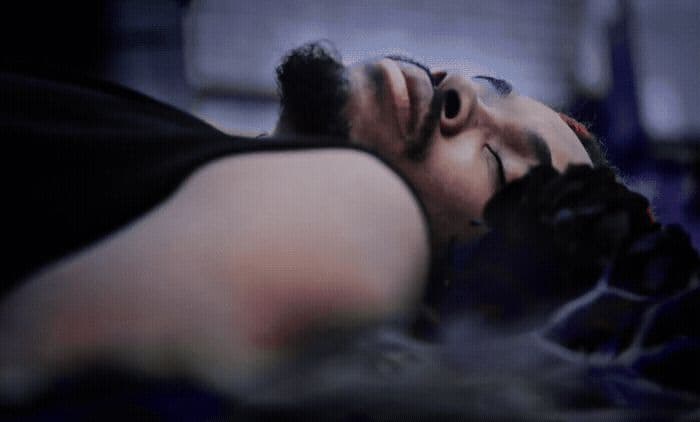 a man sleeping on a bed with his eyes closed