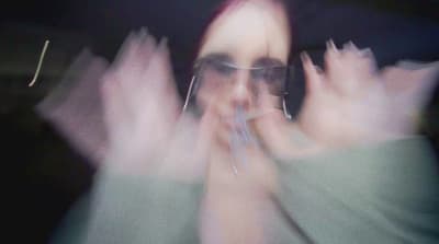 a blurry photo of a woman with her hands in the air